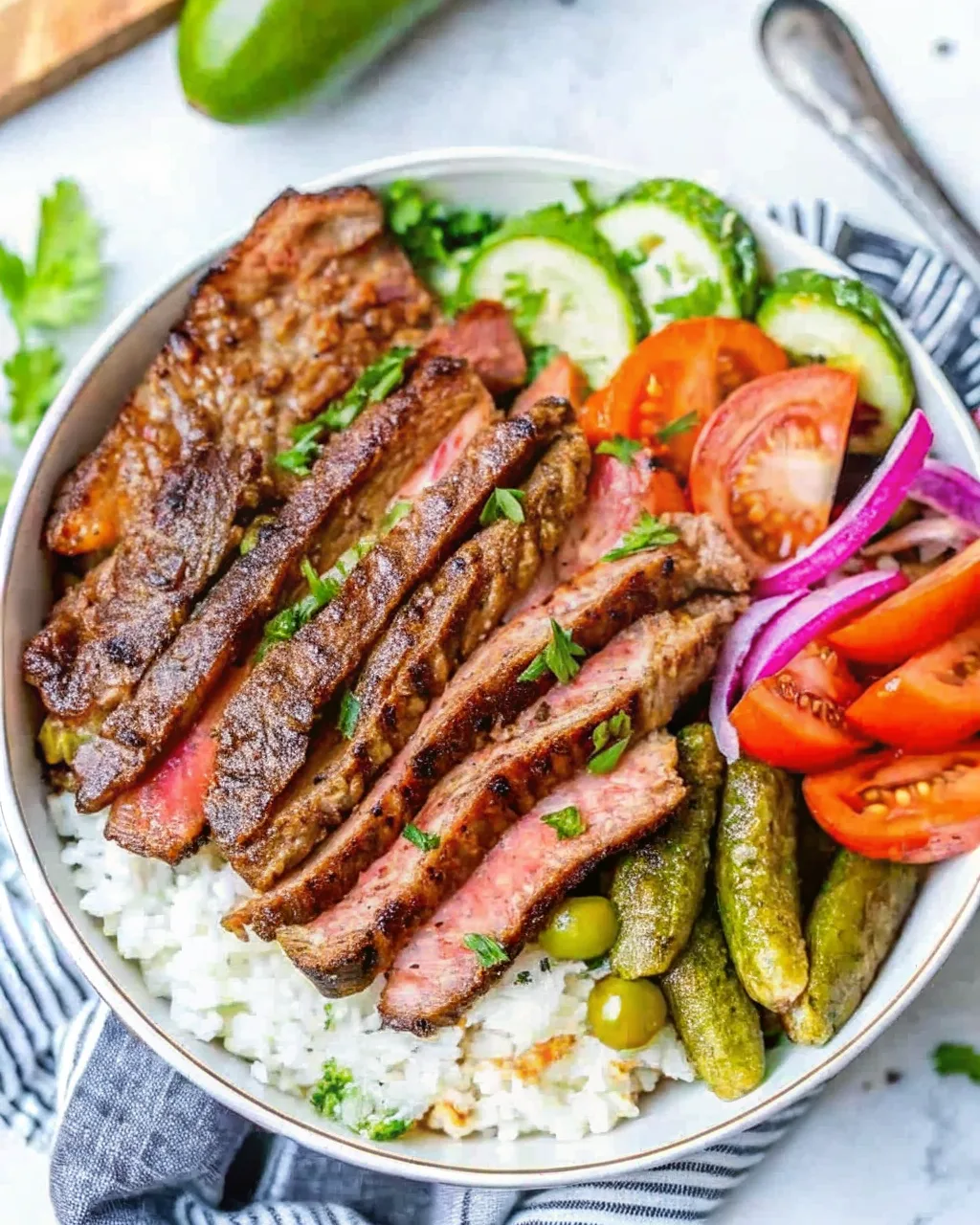 A vibrant beef shawarma bowl recipe with rice, freshly diced vegetables, and a creamy yogurt sauce, viewed from above.